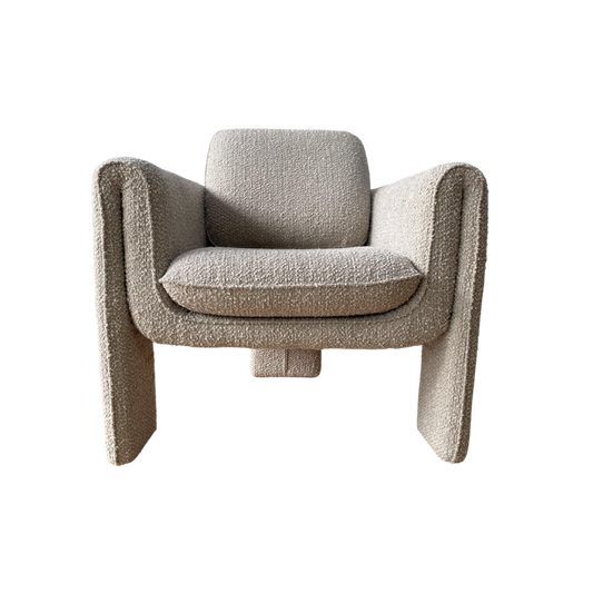 The Monica Armchair has a unique blend of curved and angular structure in a soft boucle upholstered fabric with an art deco design