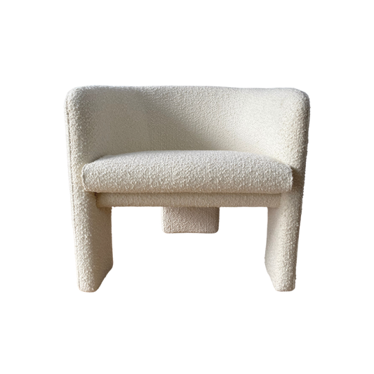 the phoebe armchair features a curved design and soft boucle fabric upholstery