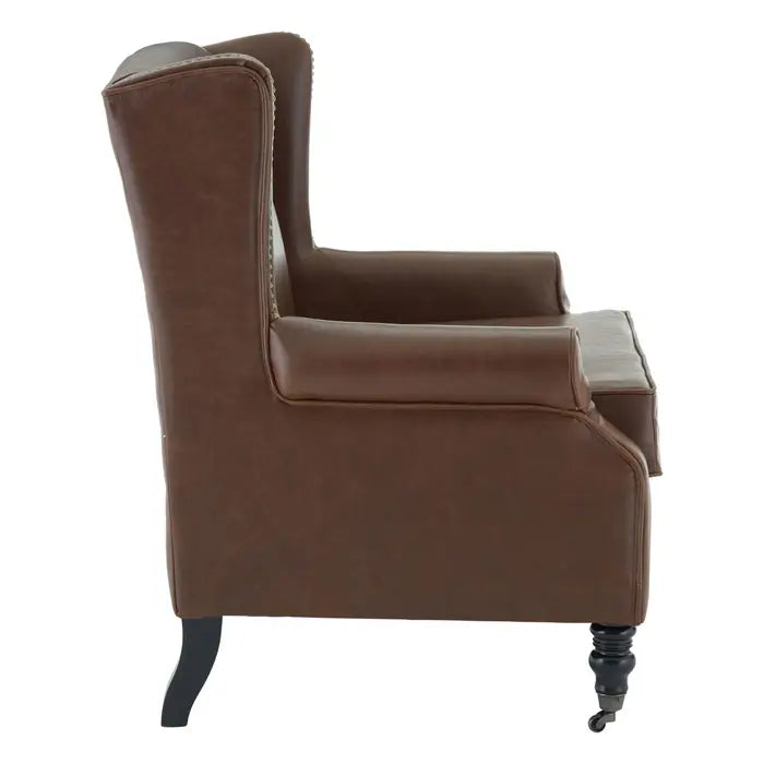 Side view Brown faux leather wing chair with gold studs and carved legs 